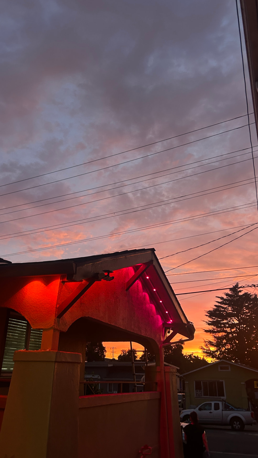Home eave glowing with red permanent LED lighting at sunset